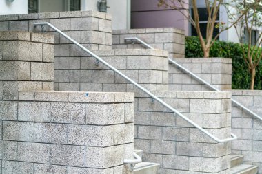 Şehir merkezindeki kentsel alanda tuğlacı tarzı veranda ya da istiflenmiş göz kırpan ve metal parmaklıklı veranda. Mahalledeki evlerin ve evlerin önünde görünür basamakları olan gölgeler.