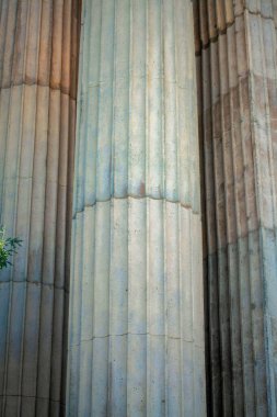 Roma İmparatorluğu tarzı sütunlar öğleden sonra gölgesinde dikey çıkıntıları olan çimento ya da taş dış yüzeyli antik kentte. Bina veya yapının tarihi eser ya da simge dış görünüşü.