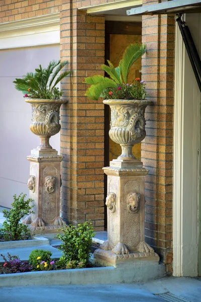 Decorative vases and planter pots on side of garage door and driveway in upper middle class wealthy areas of suburbs. In american middle class american dream home or house neighborhood in city.