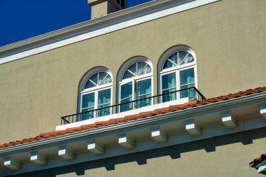 Evin ya da evin dış cephesinde gri yeşil çimento kaplamalı üç beyaz pencereli modern bina. Modern şehrin şehir merkezindeki kentsel ya da banliyö mahallesinde.