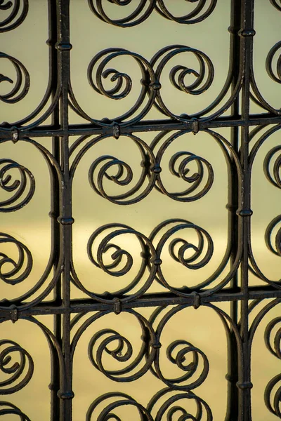Dairesel geometri tasarımlı yansıtıcı cam zeminli dekoratif metal desen ya da desen. Öğleden sonra güneş ışığı ön kapıda ya da şehir binasında.