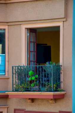 Ev ya da balkon, şehir gölgesinde bej ya da kahverengi sıva kaplı siyah metal parmaklıklı. Mahalledeki verandanın ön kapısı görünür oda detaylarına açık..