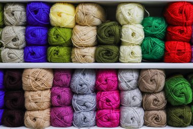 Beyaz arkaplanda örgü örmek için renkli iplikler