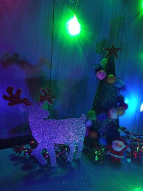 Noel Baba 'lı bir şöminenin arka planında geyik Noel süslemesi.