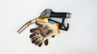 Yakıt ikmali yapıyorum. Petrol. Boş, hasarlı, kirli beyaz eldiven, tamir yağı. Beyaz arka planda benzin
