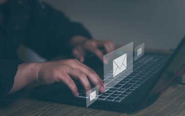 İş adamı klavyede bilgisayar kullanıyor ve ofis masasında e-posta simgesiyle internette sörf yapıyor. E- posta pazarlama fikirleri Çevrimiçi çalışan bir e- posta ya da haber ağı gönder