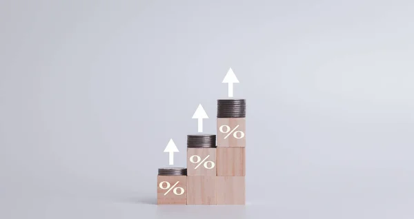 Interest on stacks of US dollars on a wooden table with an arrow pointing up. Finance and Mortgage Interest Rate Ideas wooden block with percentage icon and arrow pointing up the economy is improving