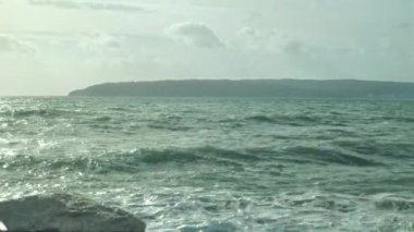 Ocean is shaking during a storm with gusty winds waves splashing on a Beach.