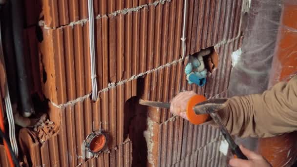 手握着凿子 紧握着锤子 建筑工人正在扩大水管道 追逐沟槽 — 图库视频影像