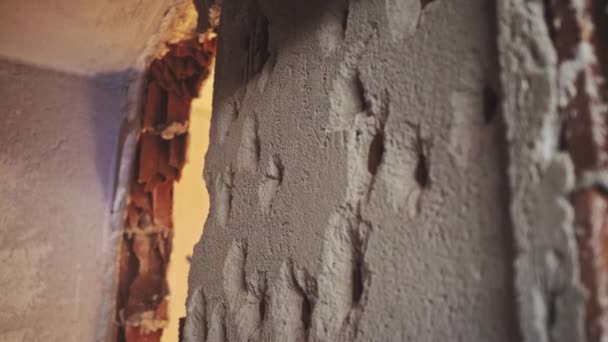 壁の穴は 壁の反対側のヘビーデューティハンマードリルの影響から作品に粉砕します プラスターと壊れたレンガのすべての方向に飛んで — ストック動画