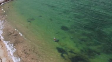 Hava manzaralı su sporu, hobi. Bir uçurtma teknisyeni, şiddetli bir yüksek hız rüzgarı sırasında tahtanın üzerinde durur.