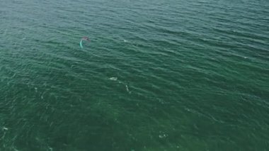 Uçurtmacının tahtadan düşüşü, yukarıdan aşağıya bakış. Aşırı su sporları. Uçurtma ve rüzgar sörfü dersleri