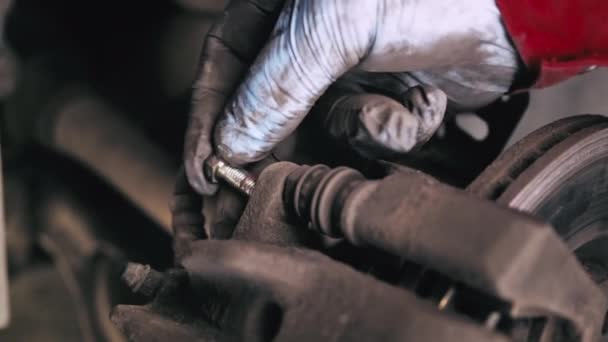 车辆维修 汽车修理工在机械修理厂修理汽车制动器 特写男性手把螺钉拧到制动器上 — 图库视频影像