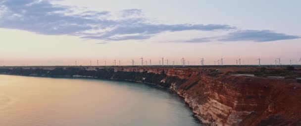 夕阳西下的时候 在海滨的斗篷上拍电影 地平线上的许多风力涡轮机产生了绿色的能量 无定形2 39范围 — 图库视频影像