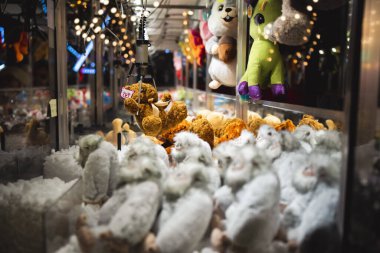 Pençe Makineleri Oyuncak Atari oyunu panayır karnavalında peluş hayvan oyuncağı yakaladı. Lunaparktaki çocuklar için eğlence