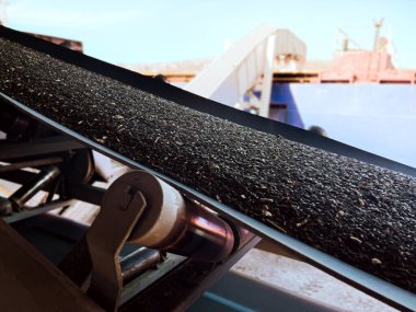 Ayçiçeği oleik tohumları taşıyıcı gemiye yükleniyor ve asansör vinci kapanıyor. İskele tahıl asansörü