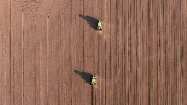 播种的种子 很少拖拉机用种子钻头播种庄稼 从无人侦察机俯瞰 图库照片