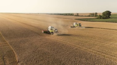 Buğday hasatçılarını birleştiren bir ekip engebeli arazide geniş açılı dron atışı yapıyorlar. Tarım endüstrisi ve tüketim vergilerinin kaldırılması nedeniyle Avrupalı çiftçilere maddi yardım