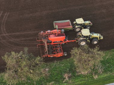 Modern tarım makineleri. Tohumları ekiciye hava yükleme tohumları. Akşamın geç saatlerinde ekin ekmek için dikey ekin ekme aracı.