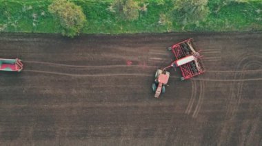 Modern tarım makineleri. Tohumları ekiciye hava yükleme tohumları. Akşamın geç saatlerinde ekin ekmek için dikey ekin ekme aracı.