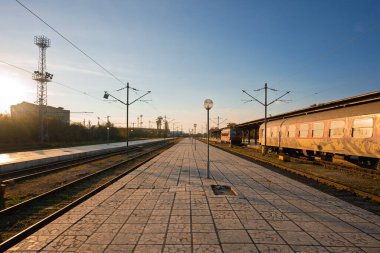 Gün batımında sessiz bir Avrupa tren istasyonu. Grafiti kaplı bir tren, boş bir platform ve nostaljik seyahat titreşimleri.. 