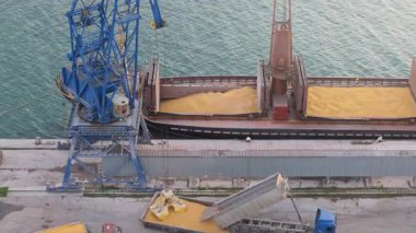 Tahıl Nakliyesi Endüstrisi. Port Terminal 'de mısırı vinçle yüklüyorum. Üst Manzara. 4k görüntü