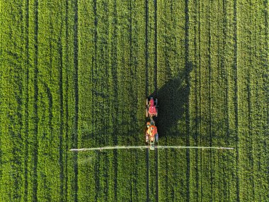 Lush Green Field 'da modern traktör ilaçlama ürünleri. Kopyalama alanı olan yukarıdan aşağıya görünüm.