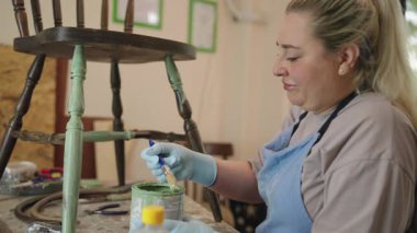 Ev atölyesinde antika ahşap sandalyeyi restore eden kadın.. 