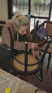 Genç bir kadın restorasyon için antika sandalyeyi söküyor. Küçük garaj işi.. 