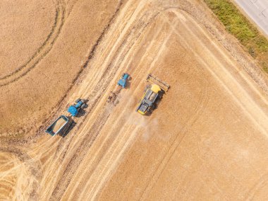 Tarım arazisinde çalışan traktör ve hasatçıların yukarıdan çekimleri 