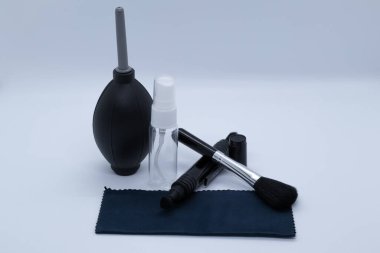 Beyaz arka planda kameralar ve çeşitli nesneler için temizlik malzemeleri