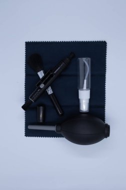 Beyaz arka planda kameralar ve çeşitli nesneler için temizlik malzemeleri