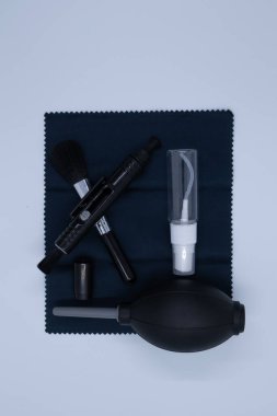 Beyaz arka planda kameralar ve çeşitli nesneler için temizlik malzemeleri