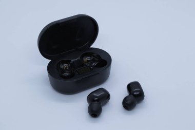 Beyaz arka planı olan siyah kablosuz kulaklıklar.