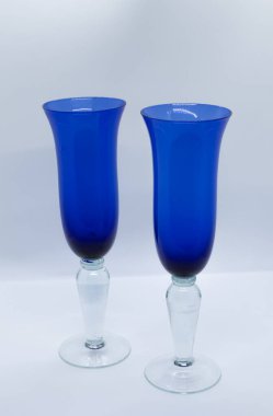 Beyaz arka planı olan mavi cam şarap kadehleri.
