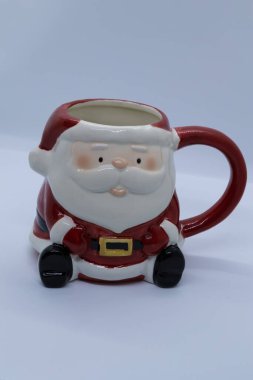 Beyaz arka planda seramik yapılmış Noel Baba kupası.
