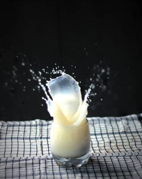 splashing milk from a glass cup isolated on the background.