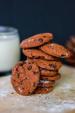 Tahta kesme tahtasında servis edilen çikolatalı bisküviler. Besleyici atıştırmalık, tatlı ya da kahvaltı. Siyah arka plan. Yiyeceğe yakın çekim. Kuru üzümlü kek..