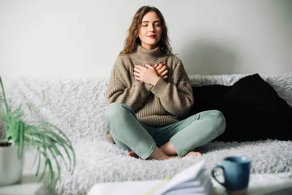 Nilüfer çiçekli güzel bir kadın yatakta poz veriyor. Pranayama nefes alma teknikleri uyguluyor. Stresli bir günün ardından iç dengeyi kuruyor..