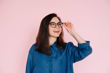 Meraklı Kadın Dokunan Gözlükler, Derin Düşünce, Boş Uzayda İlham Aranıyor: İzole Pembe Arkaplan Portresi.