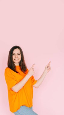 Çağırma Boşluğu: İki Parmakla Boşluğu Gösteren Neşeli Kadın - Pembe Arkaplanda İzole Edilmiş Uygun Fırsatlara Dikkat Çekme.