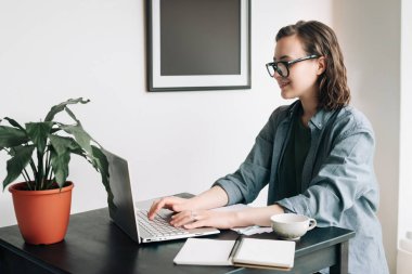 Ofiste dizüstü bilgisayar kullanan profesyonel bir genç kadın. Öğrenci kız evden uzakta çalışıyor. Evden çalış ya da çalış, serbest çalış, iş yap ve yaşam tarzı kavramını benimse. Teknoloji, verimlilik, eğitim.