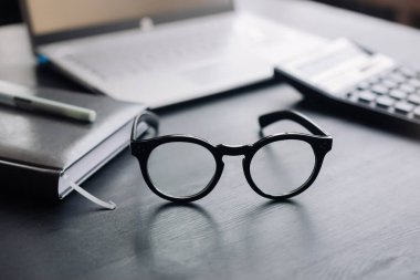 Gözlüklü, Hesaplayıcı ve Dizüstü bilgisayarlı Organize Ofis Çalışma Alanı: Mali Danışman, Bütçe, Vergi, Tasarruf ve İş Konsepti.