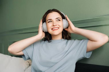 Chill and Melodies. Happy Young Woman Immersed in Weekend Music. Soothing Sounds. Woman in Wireless Headphones Enjoying Weekend Beats. clipart