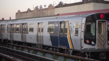 Çağdaş bir şehir metro treni, altın saat boyunca güzelce aydınlatılmış, yüksek raylarda görülebilir.