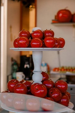 Beyaz stantta şekerli kırmızı elmalar. Bayram pazarında beyaz bir stantta sergilenen kırmızı elmalar geleneksel tatlı ve kutlama hediyelerini sembolize ediyor.