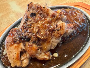 Cızırdayan tabakta soslu tavuk bifteği..