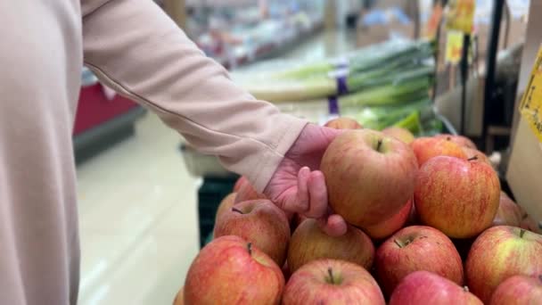 Μια Γυναίκα Χέρι Επιλέγοντας Ένα Μήλο Για Αγοράσει Ένα Σούπερ — Αρχείο Βίντεο