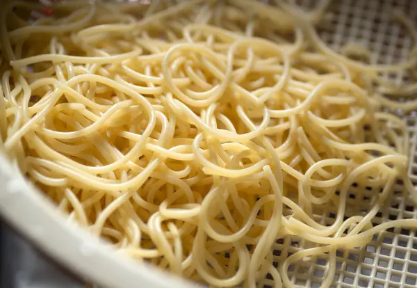 stock image Draining pasta noodles in a plastic colander strainer