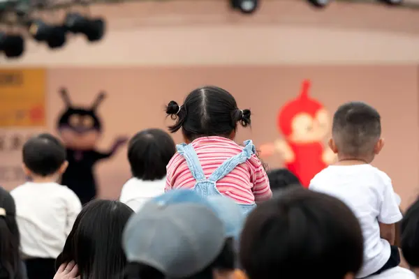 Mizumaki, Fukuoka, Japonya - 26 Ekim 2024: Çocuklar Mizumaki Cosmos Festivali 'nde Anpanman gösterisini izlemek için ailelerinin omuzlarında oturuyorlar  